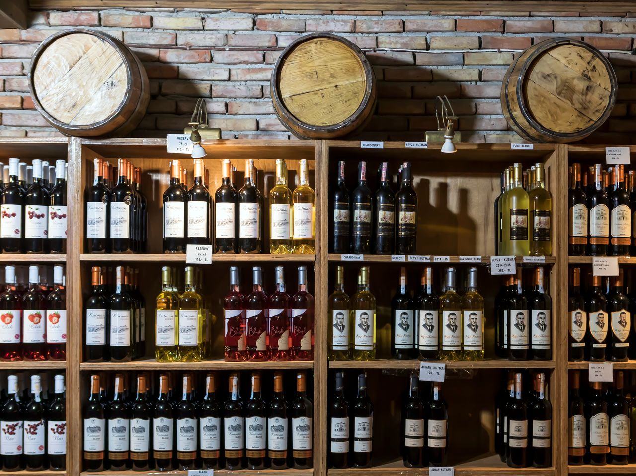 Mastering the First Impression: Your intriguing post title goes here A rustic wine cellar showcasing a variety of wine bottles against a brick wall and wooden barrels.
